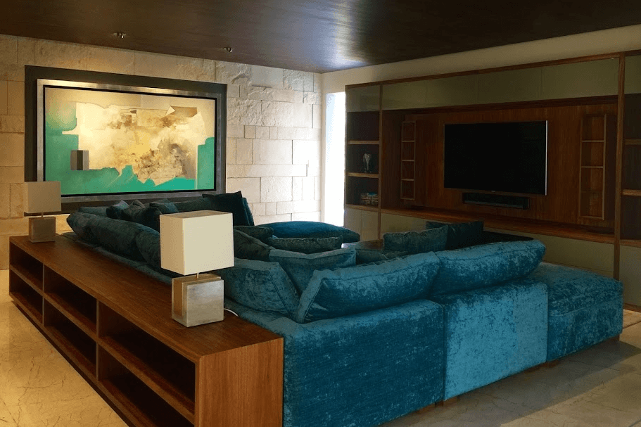 Sala con sillón tapizado en azul y mueble de tv